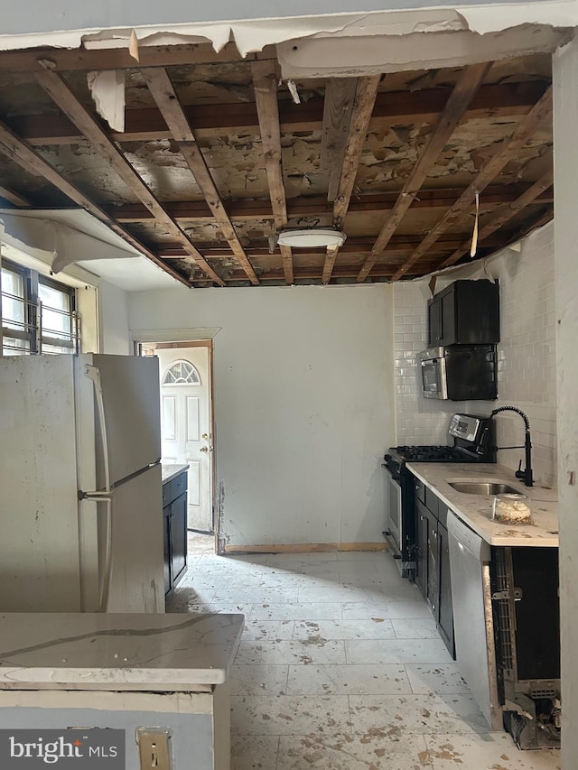 1907 Page St, Philadelphia, PA 19121 - kitchen with appliances with stainless steel finishes, a sink, and dark cabinetry