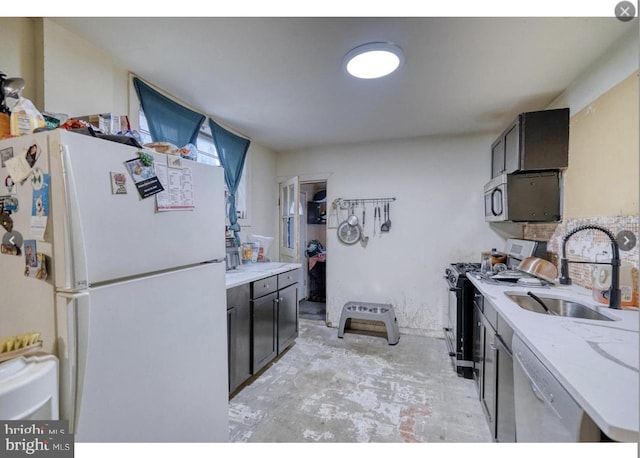 kitchen featuring light stone countertops, stainless steel appliances, and sink