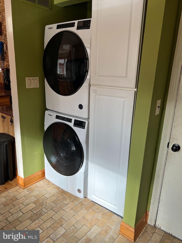 laundry room with stacked washer / dryer