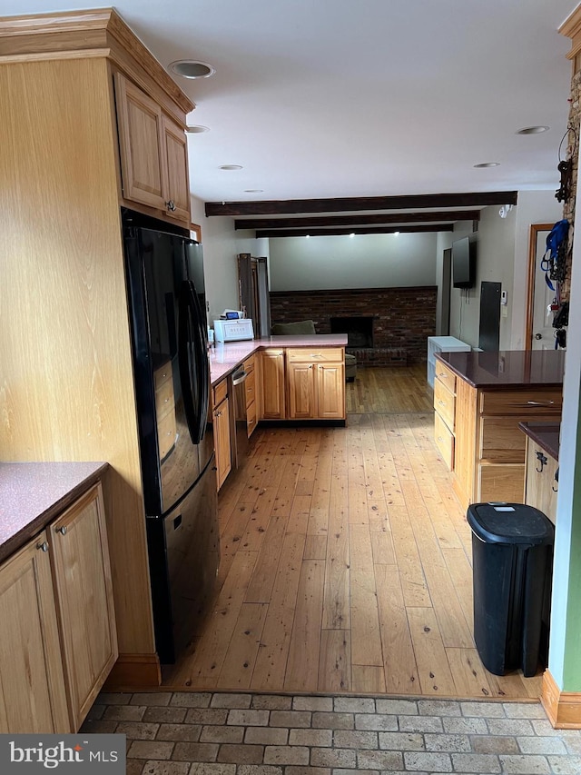 kitchen featuring black refrigerator, light brown cabinets, light hardwood / wood-style flooring, and stainless steel dishwasher