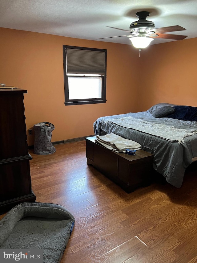 bedroom featuring ceiling fan, wood-type flooring, and a textured ceiling