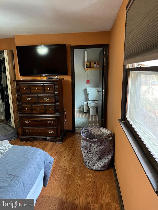 bedroom featuring wood-type flooring and connected bathroom