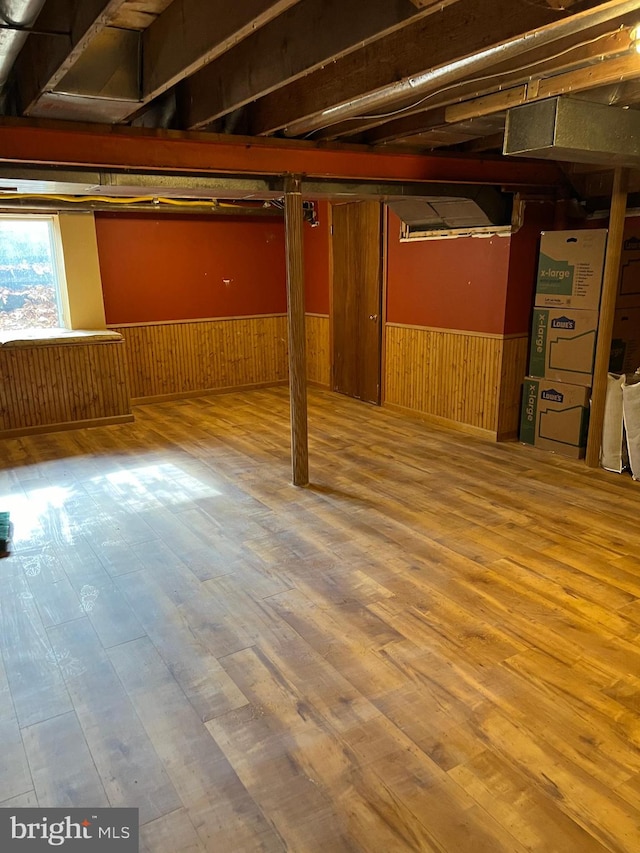 basement featuring wood walls and hardwood / wood-style flooring