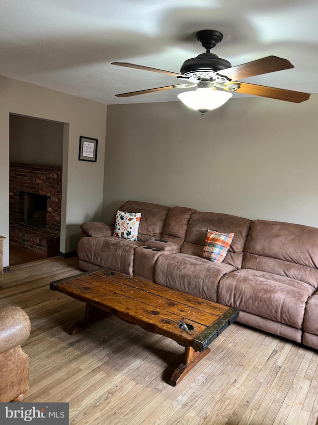 living room featuring ceiling fan and light hardwood / wood-style floors