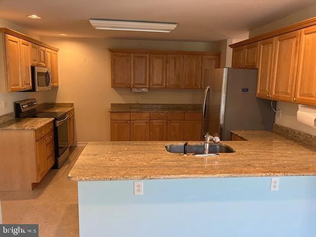 kitchen featuring kitchen peninsula, sink, and appliances with stainless steel finishes