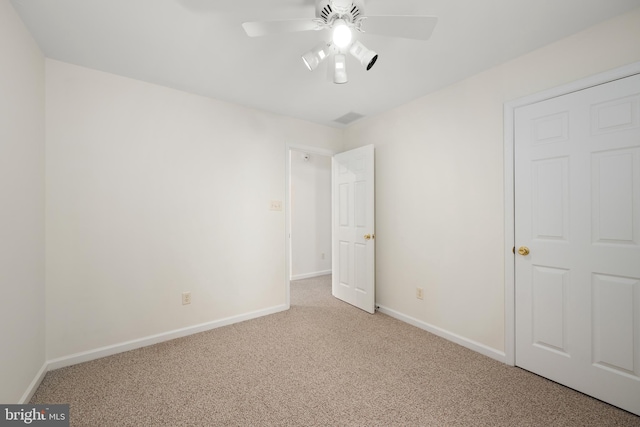 unfurnished bedroom featuring light carpet and ceiling fan