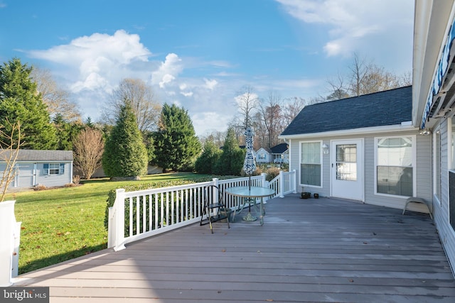 wooden deck featuring an outbuilding and a yard