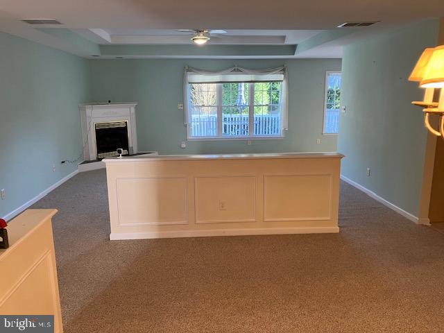 kitchen featuring ceiling fan and dark carpet