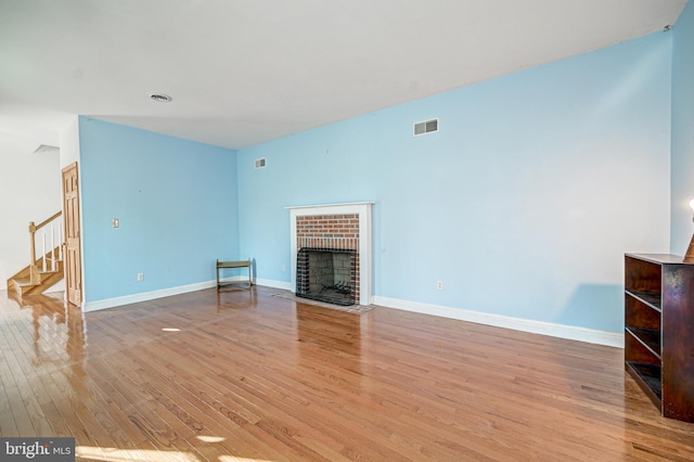 unfurnished living room featuring a fireplace and light hardwood / wood-style floors