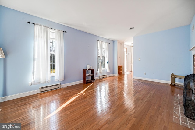 unfurnished living room with a baseboard radiator and hardwood / wood-style flooring