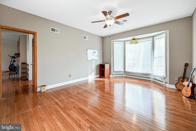 interior space with hardwood / wood-style flooring, ceiling fan, and a baseboard radiator