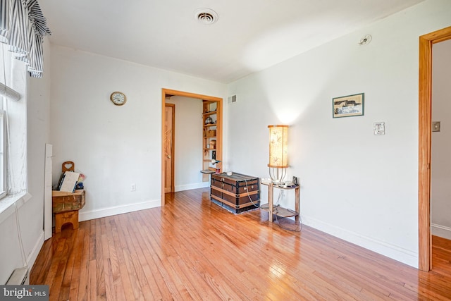 interior space with wood-type flooring and a baseboard heating unit