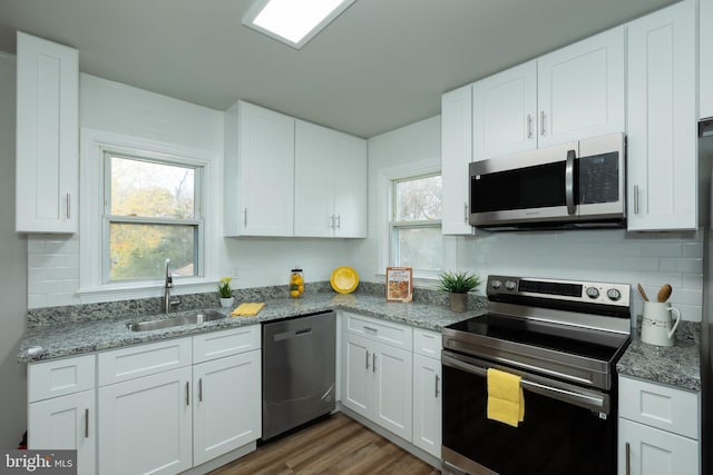 kitchen with sink, white cabinets, plenty of natural light, and appliances with stainless steel finishes