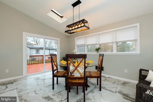 dining area featuring lofted ceiling with skylight