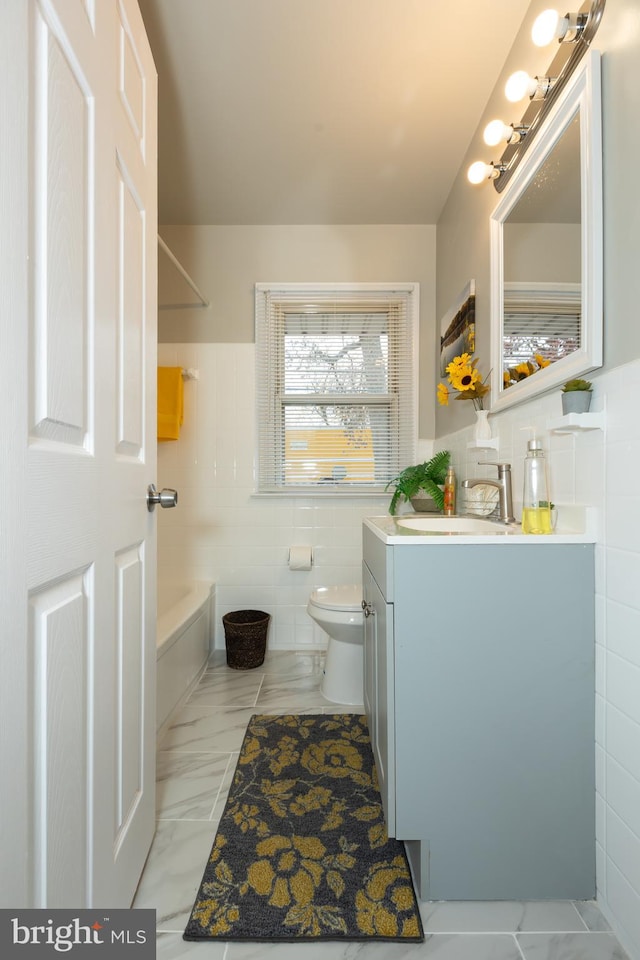 bathroom featuring vanity, tile walls, and toilet