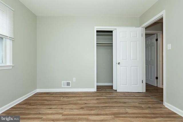 unfurnished bedroom featuring a closet and light hardwood / wood-style flooring