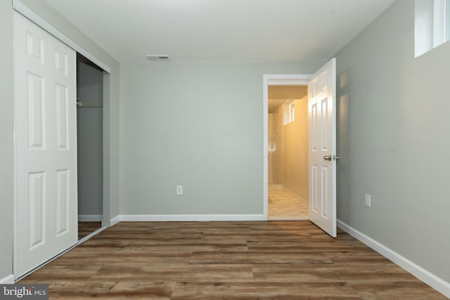 unfurnished bedroom featuring a closet and hardwood / wood-style floors