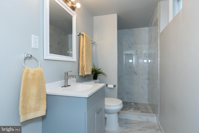 bathroom featuring vanity, toilet, and a tile shower