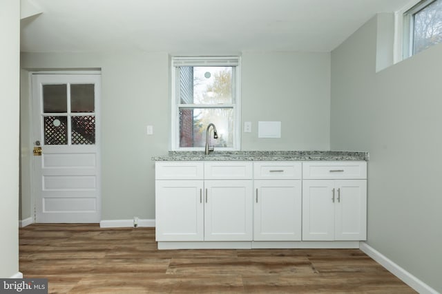 interior space with a wealth of natural light, light hardwood / wood-style flooring, and white cabinets