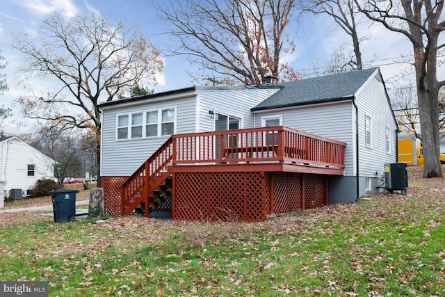 rear view of house featuring cooling unit, a lawn, and a wooden deck