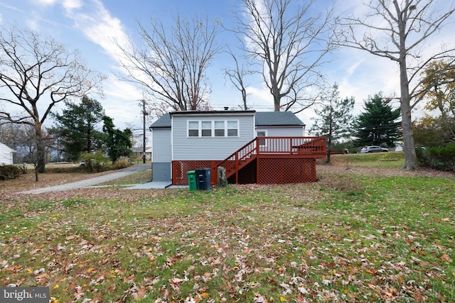 rear view of property with a lawn and a wooden deck