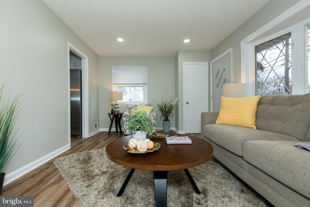 living room with plenty of natural light and dark wood-type flooring