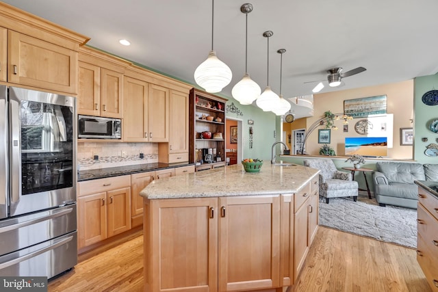 kitchen featuring a center island with sink, appliances with stainless steel finishes, and light hardwood / wood-style flooring