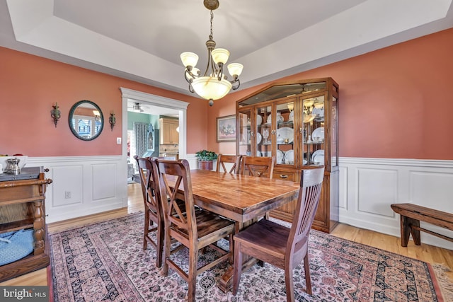 dining room featuring light wood-type flooring and an inviting chandelier