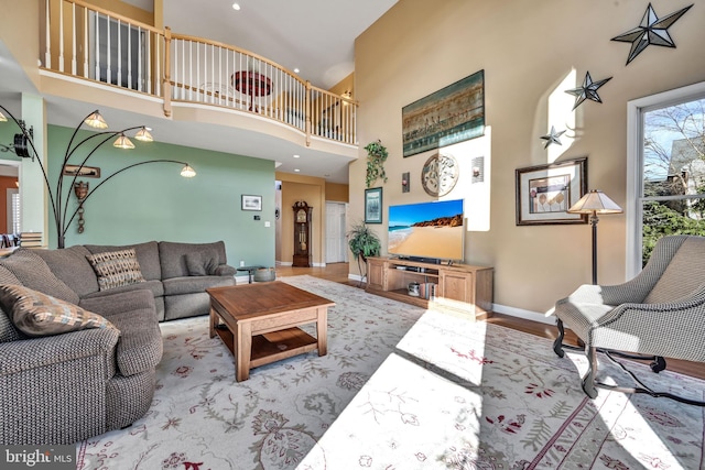 living room featuring a towering ceiling and light hardwood / wood-style flooring