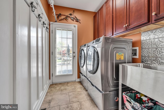 laundry room with cabinets and washing machine and clothes dryer