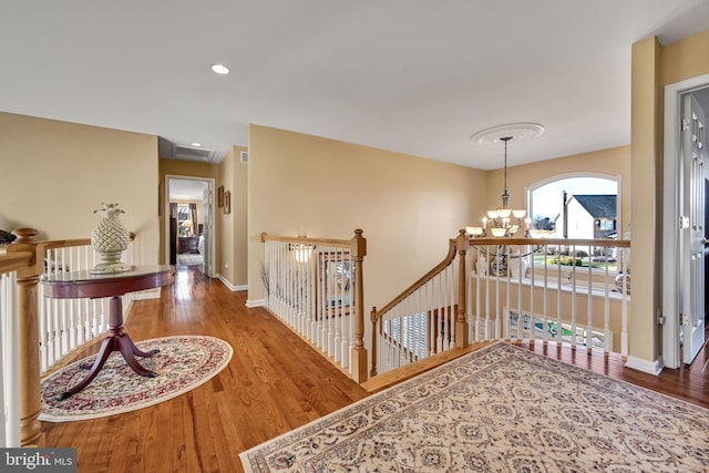 corridor featuring hardwood / wood-style floors and a notable chandelier