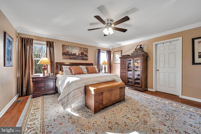 bedroom featuring light wood-type flooring, multiple windows, ornamental molding, and ceiling fan