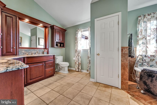 bathroom with vanity, lofted ceiling, tile patterned flooring, toilet, and a tub to relax in