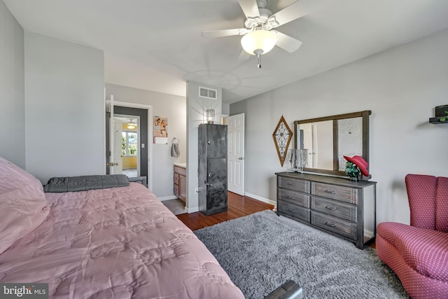 bedroom featuring ceiling fan, ensuite bathroom, and dark wood-type flooring