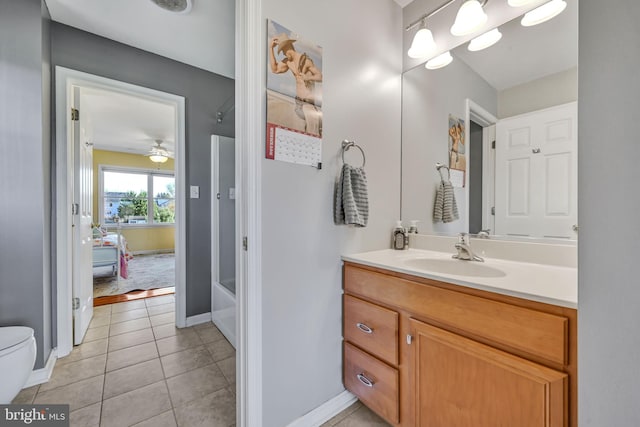 bathroom featuring a bathing tub, ceiling fan, tile patterned floors, toilet, and vanity