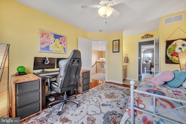 bedroom featuring ceiling fan with notable chandelier and hardwood / wood-style flooring