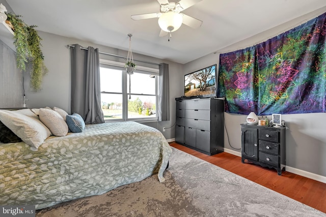 bedroom with ceiling fan and dark hardwood / wood-style flooring