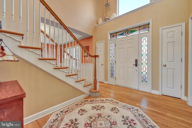 entryway featuring hardwood / wood-style floors and a high ceiling