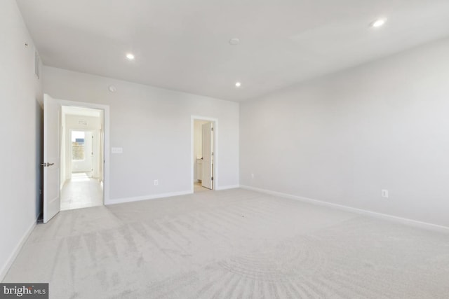 unfurnished bedroom featuring ensuite bath and light colored carpet