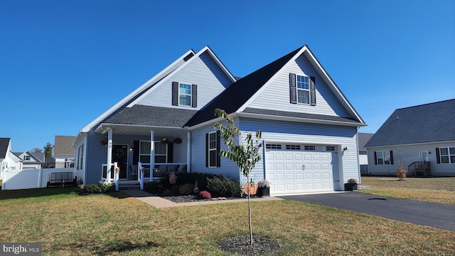 view of front of house with a porch, a garage, and a front lawn