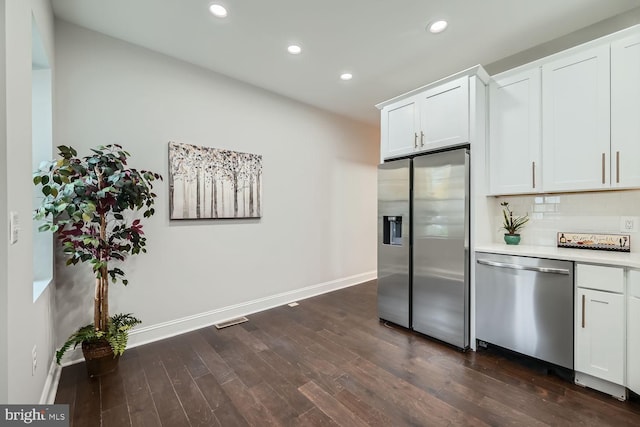 kitchen with dark hardwood / wood-style flooring, white cabinetry, stainless steel appliances, and tasteful backsplash