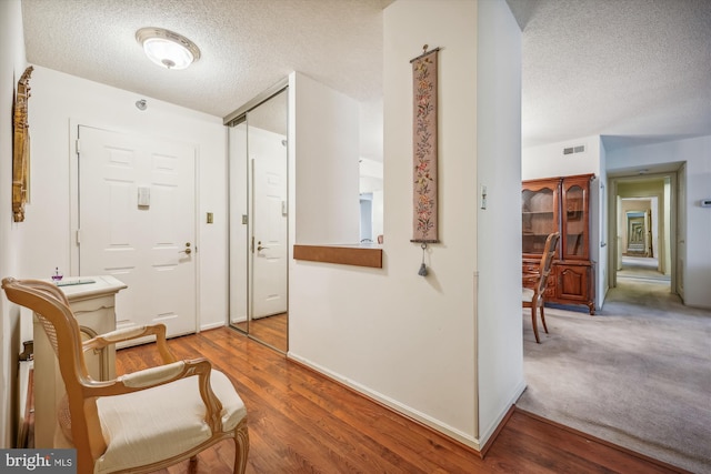 foyer entrance with hardwood / wood-style flooring and a textured ceiling