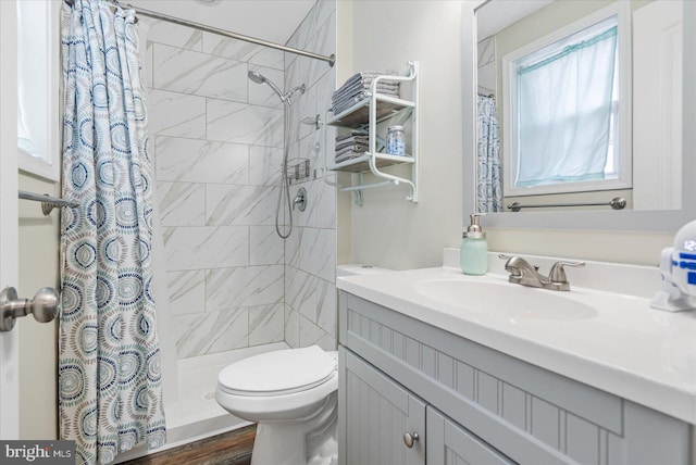 bathroom with hardwood / wood-style floors, vanity, toilet, and walk in shower