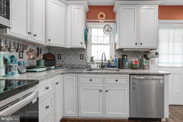 kitchen featuring sink, light stone counters, decorative backsplash, white cabinets, and appliances with stainless steel finishes