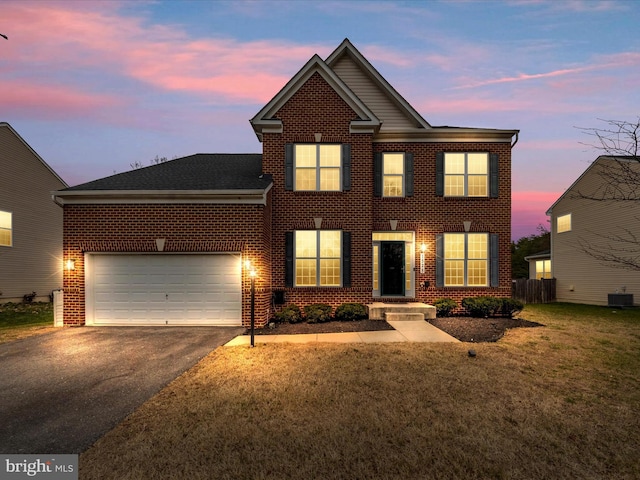 view of front of home featuring central AC unit, a garage, and a yard