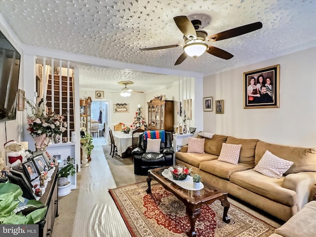 living room featuring a textured ceiling and ceiling fan