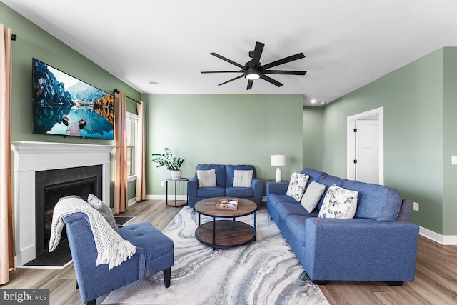 living room featuring wood-type flooring and ceiling fan