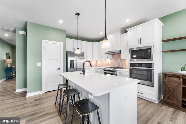 kitchen featuring white cabinetry, a kitchen island with sink, sink, and appliances with stainless steel finishes