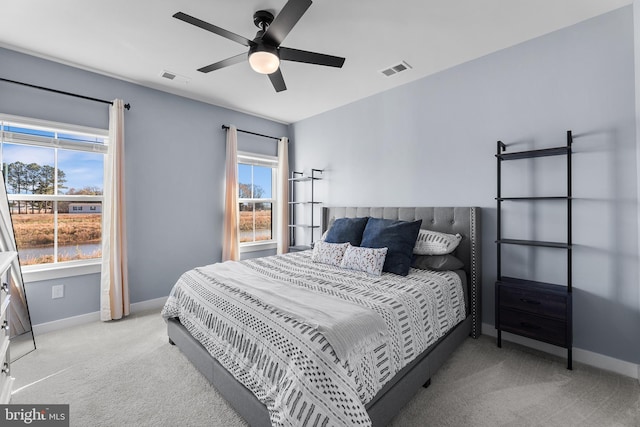 carpeted bedroom with multiple windows and ceiling fan