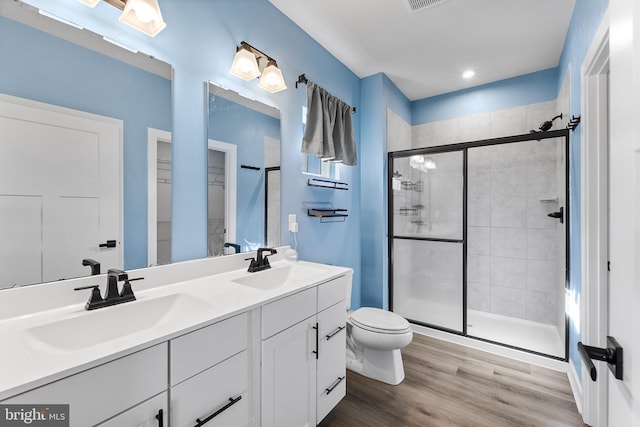 bathroom with vanity, hardwood / wood-style flooring, toilet, and an enclosed shower